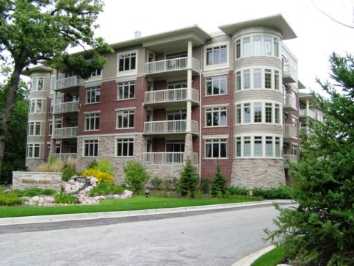 Front view of a multi-story brick residential building with balconies.