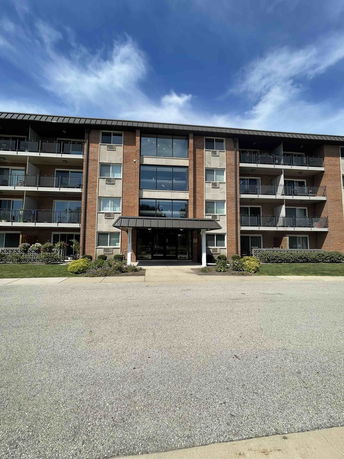 Front view of a multi-story apartment building with balconies.