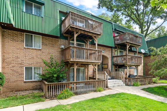 Front view of a residential building with balconies and a brick facade.