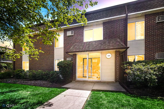 Front view of a brick apartment building with a glass door entrance.