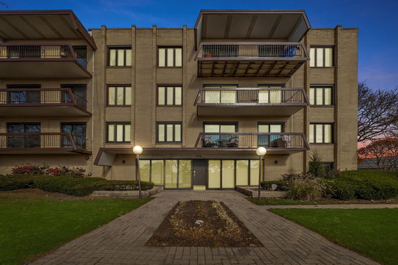 Front view of a multi-story apartment building with balconies.