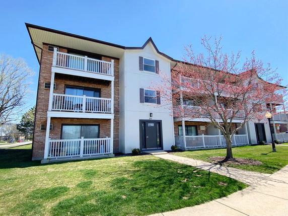 Front view of a multi-story residential building with balconies.