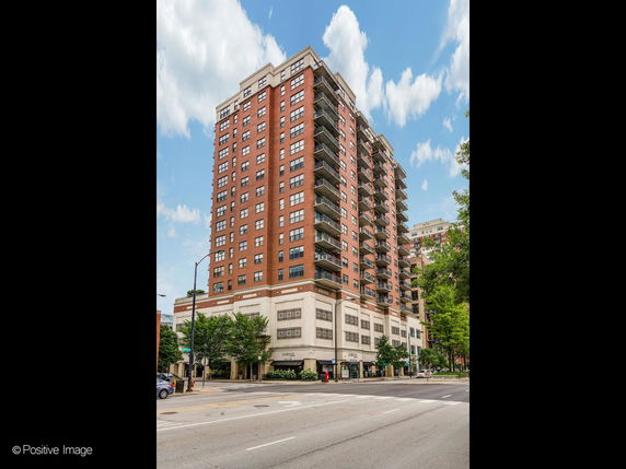 Front view of a multi-story apartment building with balconies.