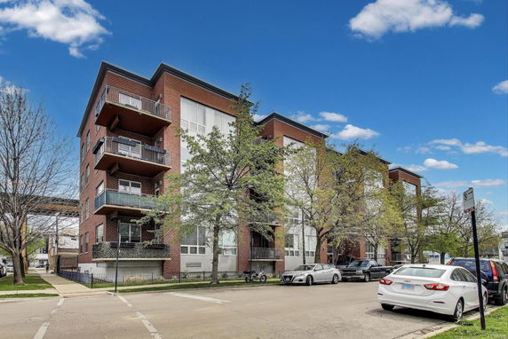 Front view of a multi-story apartment building with balconies.