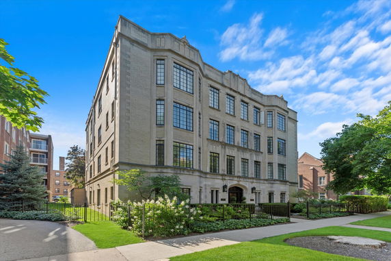 Front view of a multi-story residential building with large windows.