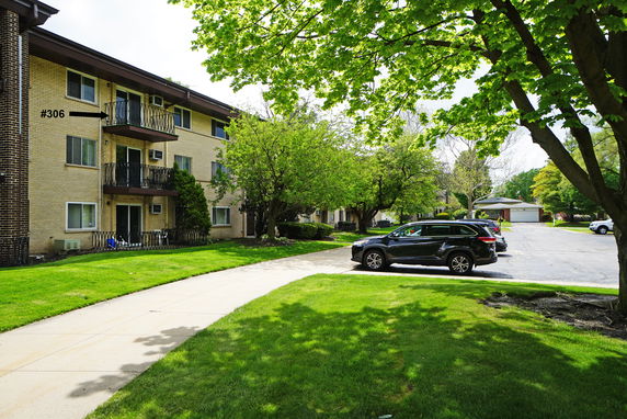 Front view of a multi-story apartment building with balconies.