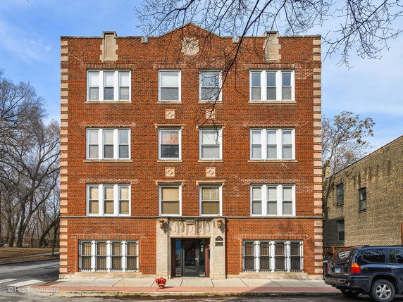 Front view of a four-story brick apartment building.