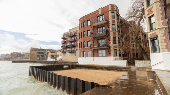 Front view of a multi-story brick building by the water.