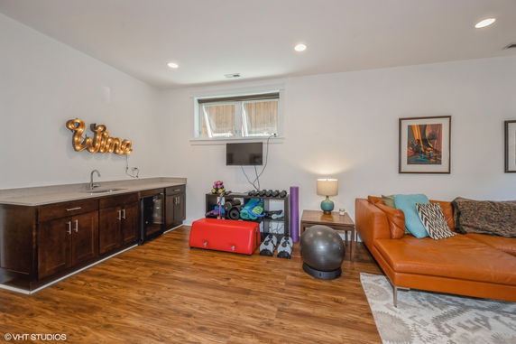 Room with exercise equipment, a couch, and a countertop with cabinets.