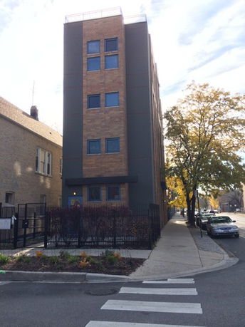 Front view of a multi-story building on a street corner.