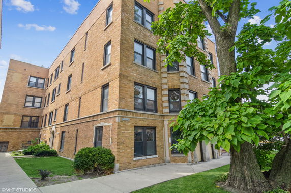 Front view of a multi-story brick apartment building.