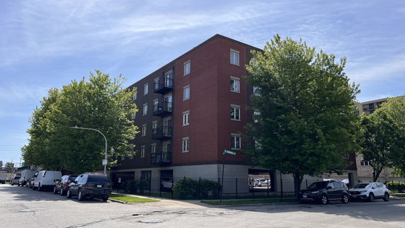 Front view of a multi-story brick apartment building.