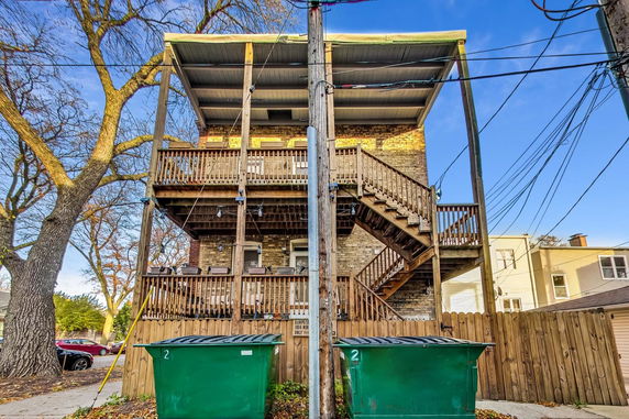 Rear view of a multi-story building with wooden staircases and balconies.