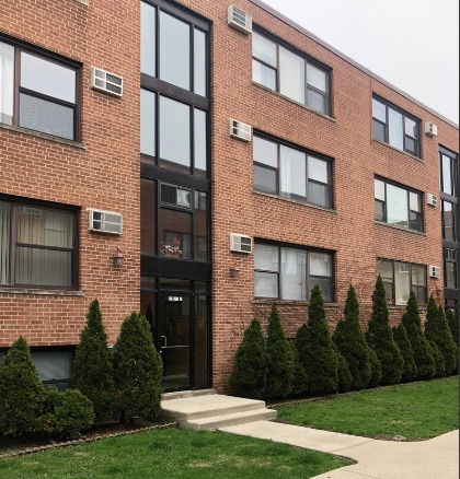 Front view of a multi-story brick apartment building.