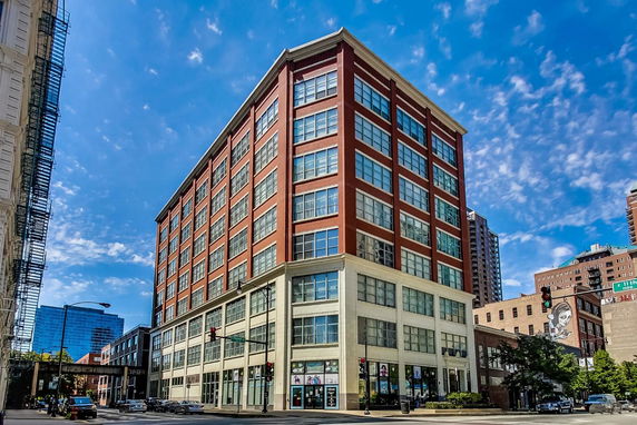 Front view of a multi-story brick building with large windows.