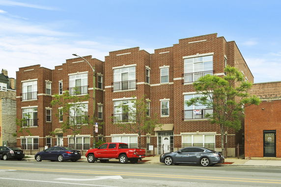 Front view of a multi-story brick apartment building.
