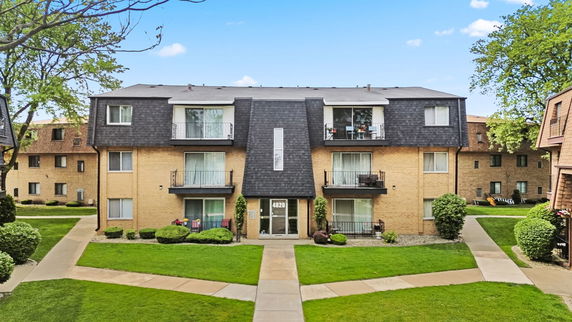 Front view of a multi-story residential building with balconies.