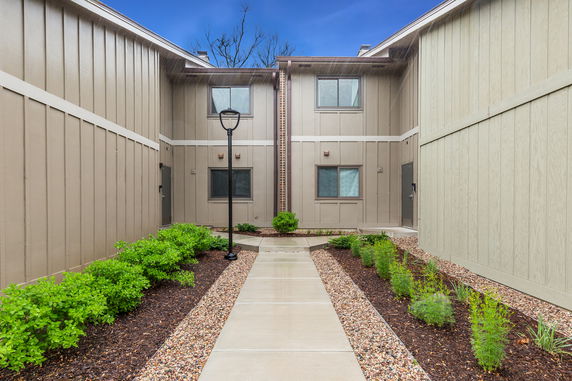 Front view of a two-story building with beige panel siding and windows.