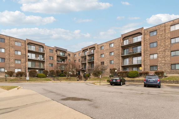 Front view of a multi-story apartment building with brick exterior.