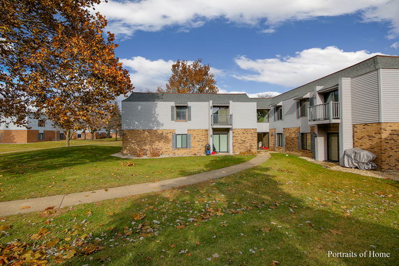 Front view of a two-story apartment building with brick and siding finish.