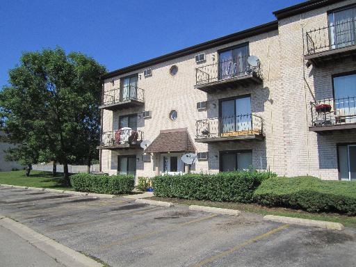 Front view of a three-story apartment building with balconies.