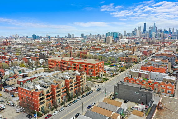 Panoramic view of urban landscape with various buildings and a distant city skyline.