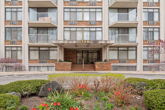 Front view of a multi-story building with balconies and a main entrance.