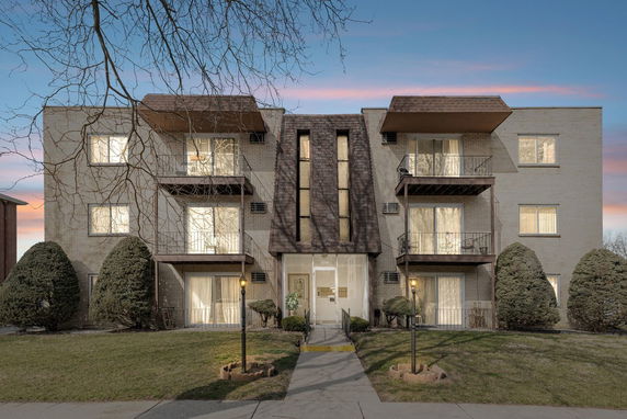 Front view of a multi-story apartment building with balconies.