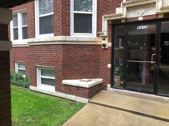 Front view of a brick building with a glass door entrance.