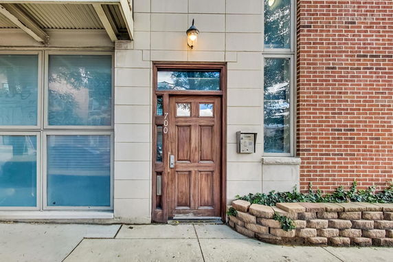 Entrance view of a building with a wooden door and brick exterior.