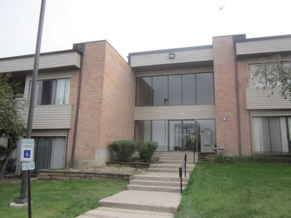 Front view of a two-story building with large windows and brick walls.
