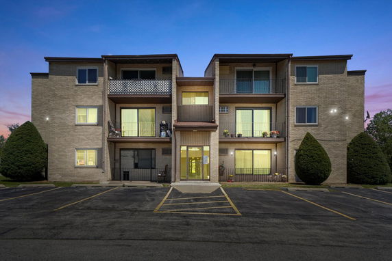 Front view of a three-story apartment building with balconies.
