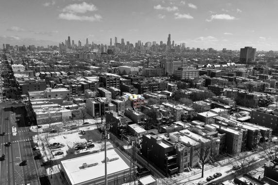 Panoramic view of a cityscape with numerous buildings and a skyline in the distance.