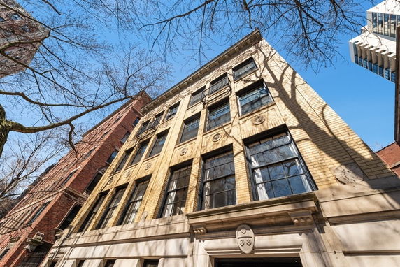 Front view of a multi-story brick building with large windows and decorative stone elements.