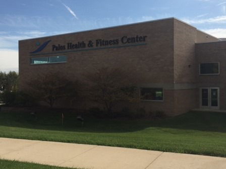Front view of a fitness center building with brick exterior.