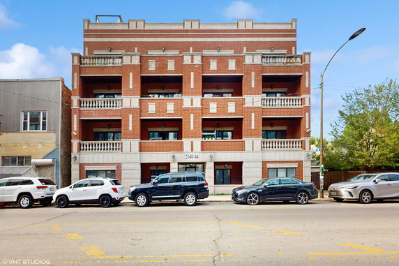 Front view of a multi-story brick building with balconies.