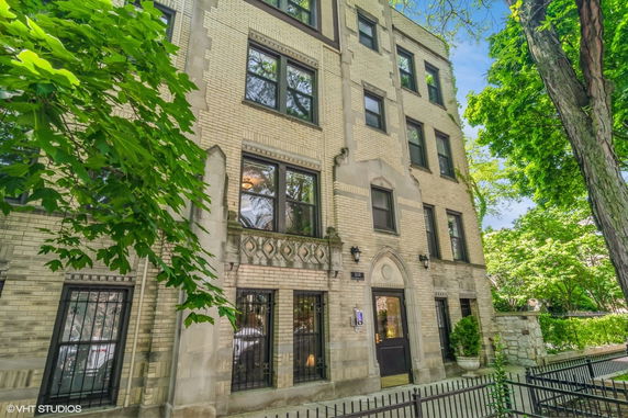 Front view of a multi-story brick building with decorative stonework.