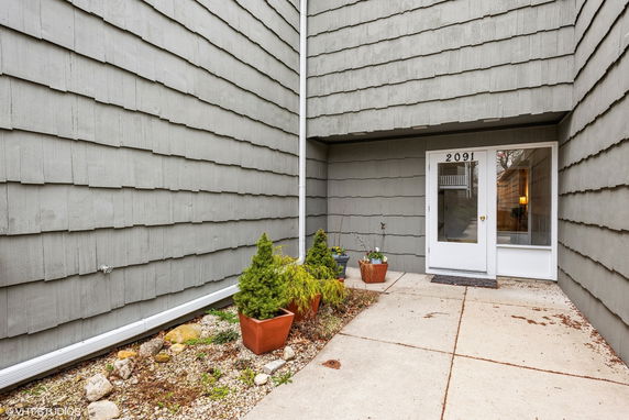 Front view of a house with exterior wall siding and entrance door.