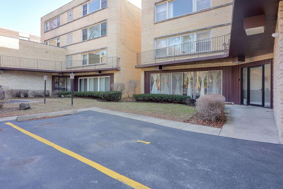 Front view of a multi-story building with large windows and a small entrance area.