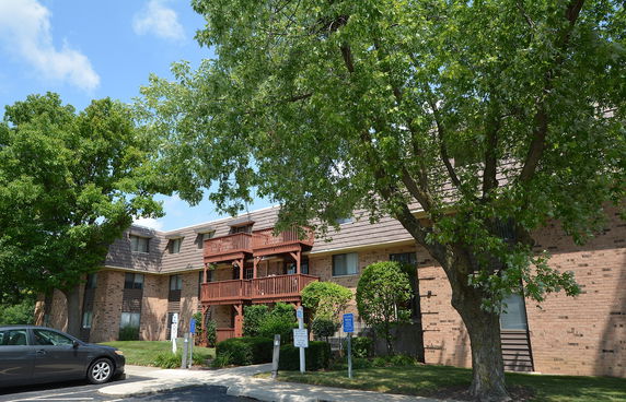 Front view of a multi-story brick residential building with balconies.