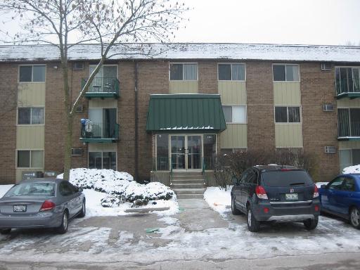 Front view of a multi-story apartment building with a green canopy over the entrance.