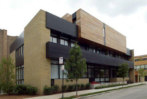 Front view of a modern two-story building with a combination of wood and dark paneling.