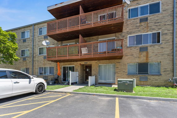 Front view of a multi-story apartment building with balconies.
