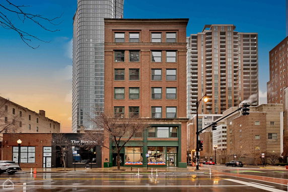 Front view of a multi-story brick building in an urban area.