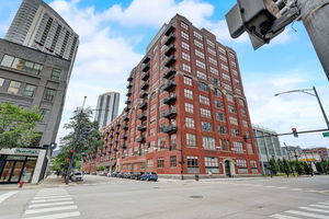 Front view of a multi-story brick apartment building on a corner street.