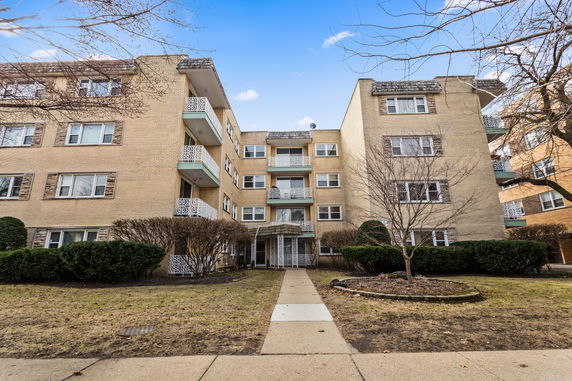 Front view of a multi-story residential building with balconies.