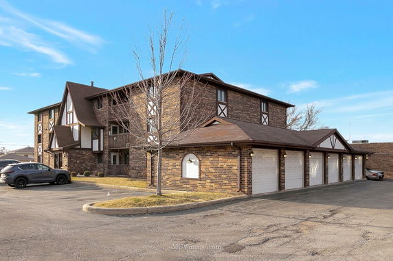 Front view of a three-story building with a row of garages attached.