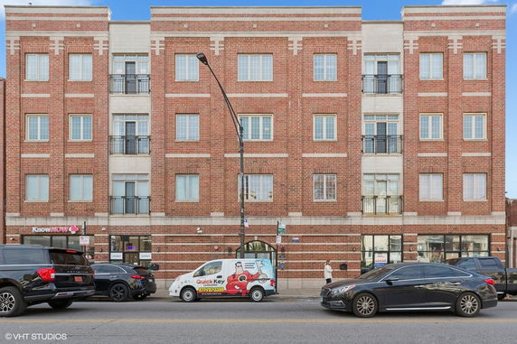 Front view of a multi-story brick building with multiple windows and balconies.