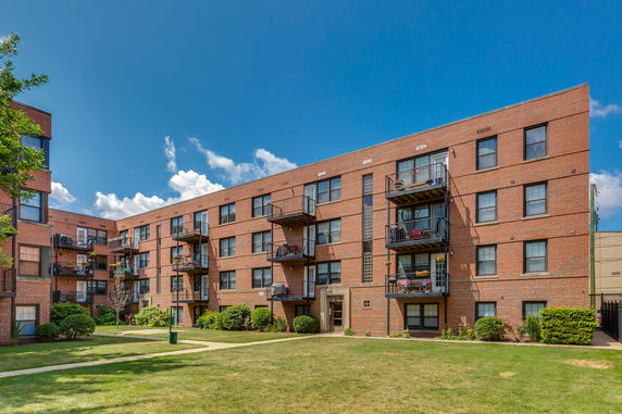 Front view of a brick apartment building with balconies.