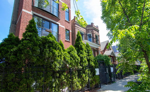 Front view of a multi-story brick building with balconies.